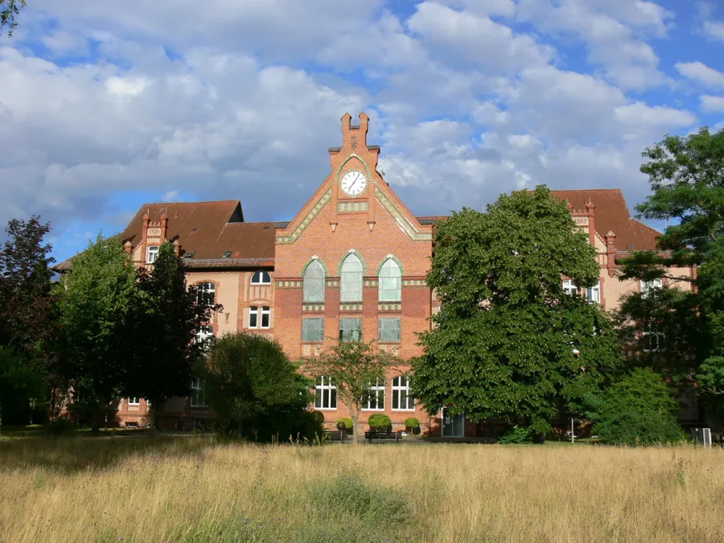 Aussenansicht des Seniorenheim Friedensau mit Wiese und Bäumen